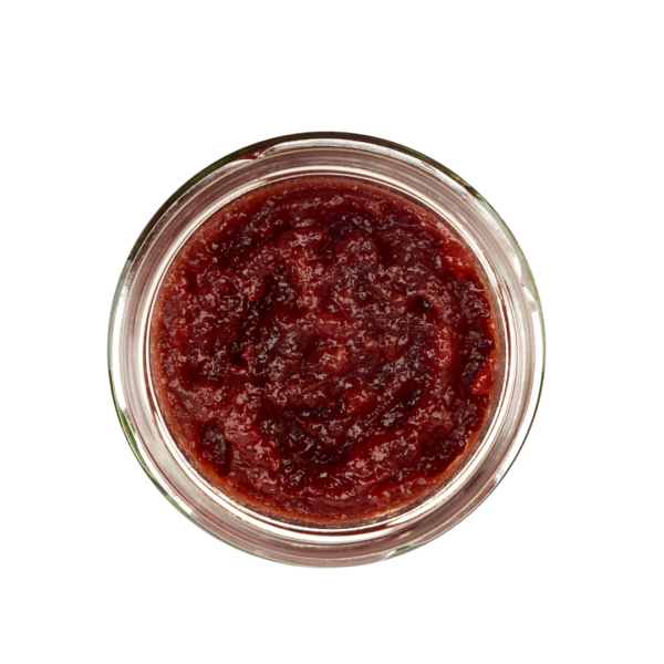 Lund-Sylt-marmelade-Kirsche-op.png Draufsicht auf ein mit roter Marmelade gefülltes SAUERKIRSCH-Glas, das seine strukturierte Oberfläche zeigt.