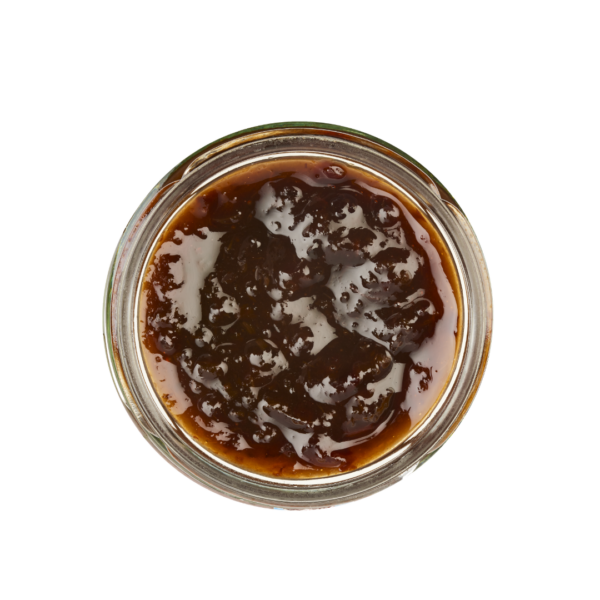 Lund-Sylt-marmelade-pflaumenmus-friesisch-open.png Draufsicht auf ein offenes Glas gefüllt mit LUNDS SYLTER PFLAUMENMUS, einer dunklen, dicken, stückigen Soße oder Konfitüre.